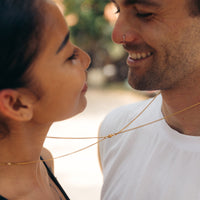 Couple wearing magnetic necklace set in gold
