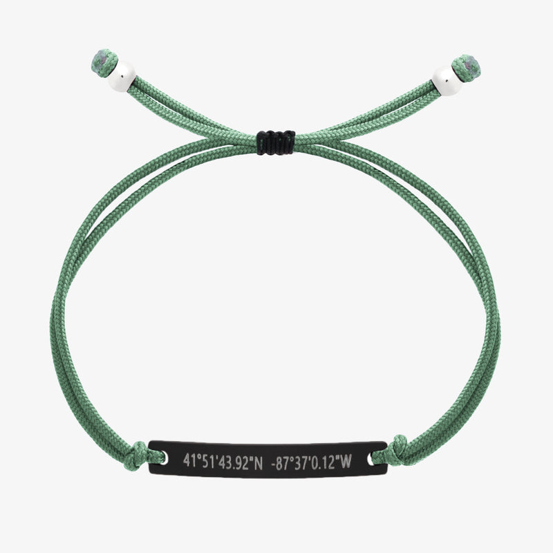 Green thread bracelet with a black bar and engraved coordinates