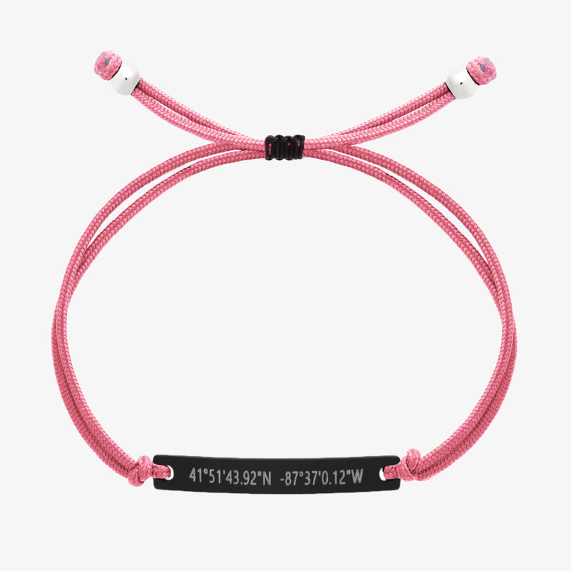 Pink thread bracelet with a black bar and engraved coordinates