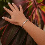 A woman wearing a customizable bracelet in silver