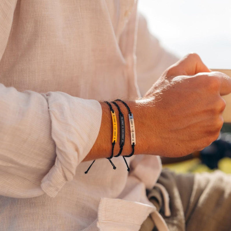 A braided bracelet made from bamboo cord with a wooden button