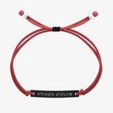 Red thread bracelet with a black bar and engraved coordinates